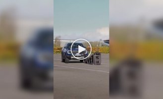 Pickup truck driving on two wheels between poles