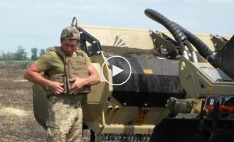 Sappers clear a farmer's field in the de-occupied territories with a mechanized mine clearing machine