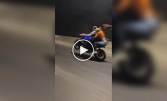 Biker rears up motorcycle with passenger on back