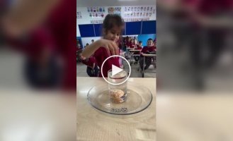 Children try to get a tangerine out of a glass of water