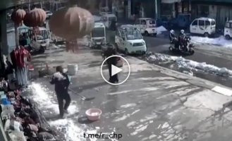 Китаянка вовремя отошла от места падения снега