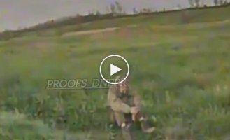 An occupier, head bowed, sits motionless and takes a kamikaze drone's blow directly to the head