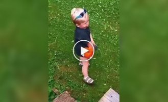 The perfect job: a toddler imitates mowing the lawn on a broken lawn mower