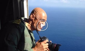 A photographer leaned out of a plane during a flight
