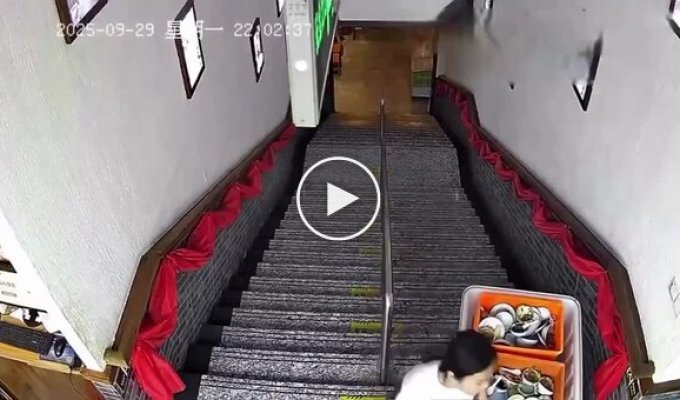 A girl tries to roll a container of dishes down the stairs