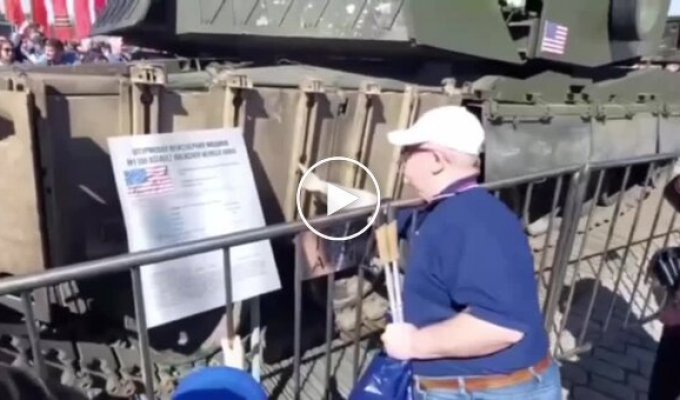 We show our fists to the American combat vehicle and film it with a captured iPhone