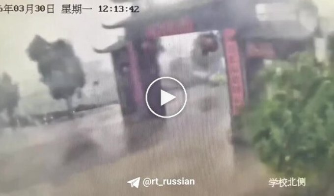 A Chinese moped rider miraculously escaped when a historic gate collapsed onto the road