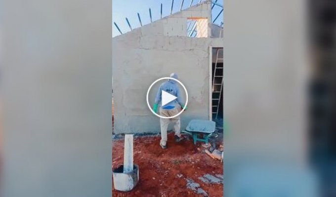 Каменяр накидає розчин на стіну